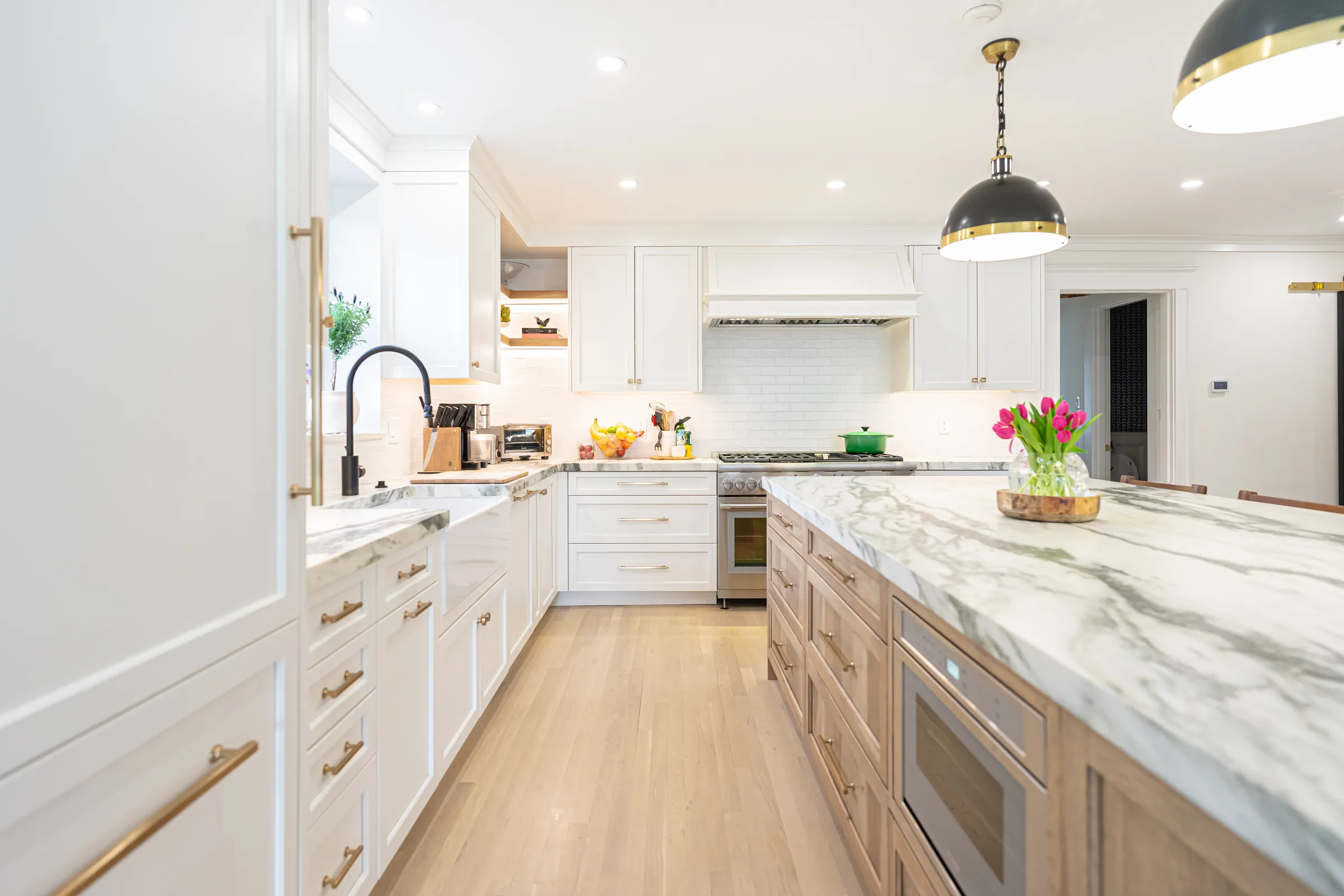 White kitchen with quartzite counters and a wood island